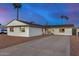 Well-maintained single-story home featuring a spacious driveway and desert landscaping under a dusk sky at 3723 S Kenneth Pl, Tempe, AZ 85282