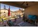 Covered patio with windchimes, a patio table, and lounge furniture at 40802 W Portis Dr, Maricopa, AZ 85138