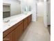 Bathroom featuring double sinks, dark wood cabinets, large mirrors, and tiled flooring at 4127 W Acorn Valley Trl, New River, AZ 85087