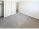 A bedroom with neutral carpet, closet, and an open doorway to the rest of the house at 4127 W Acorn Valley Trl, New River, AZ 85087