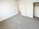 A bedroom with neutral carpet, closet, and an open doorway to the rest of the house at 4127 W Acorn Valley Trl, New River, AZ 85087