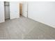A bright, carpeted bedroom with closet and a view into the hallway and entry at 4127 W Acorn Valley Trl, New River, AZ 85087