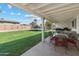 Spacious backyard patio with a covered area overlooking a lush lawn, ideal for outdoor activities and entertaining at 419 N Valencia Dr, Chandler, AZ 85226