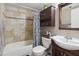 Well-lit bathroom featuring a bathtub with decorative tile and a dark wood vanity with sink and mirror at 419 N Valencia Dr, Chandler, AZ 85226