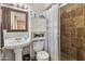 Tiled bathroom featuring a sink, a shower with a curtain, and a built-in storage cabinet at 419 N Valencia Dr, Chandler, AZ 85226