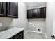 Laundry room with granite countertops and brown cabinetry at 42951 W Sandpiper Dr, Maricopa, AZ 85138