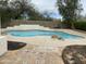 Backyard pool features cool blue water with rock accents and surrounding concrete and brick pool deck at 4402 E Creosote Dr, Cave Creek, AZ 85331
