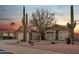 Charming home with desert landscaping, two-car garage, and tall cacti as a beautiful sunset paints the sky at 446 W Sereno Dr, Gilbert, AZ 85233