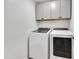 Functional laundry room with modern washer and dryer units and ample storage cabinets at 446 W Sereno Dr, Gilbert, AZ 85233