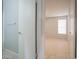 A look through the bathroom doorway to a bedroom with neutral walls, tile floors, and a bright window at 4719 E Belleview St, Phoenix, AZ 85008