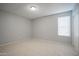 A bright bedroom with neutral walls and tile floors has a window for natural light at 4719 E Belleview St, Phoenix, AZ 85008