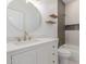 Modern bathroom features white cabinets, a round mirror and a tiled shower with built-in shelves at 501 E 2Nd Ave # 14, Mesa, AZ 85204