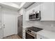 Modern kitchen with stainless steel appliances, white cabinets, and neutral tile backsplash at 501 E 2Nd Ave # 14, Mesa, AZ 85204