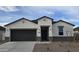 Inviting single-story home featuring a two-car garage and neutral-toned stucco, and low-maintenance desert landscaping at 5758 E Smeaton Pl, San Tan Valley, AZ 85140