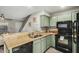 Kitchen with granite countertops, breakfast bar, black appliances, and wood-look tile floors at 5808 E Brown Rd # 106, Mesa, AZ 85205
