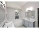 Modern bathroom with double sinks, a soaking tub, and gray cabinetry at 6323 E Nisbet Rd, Scottsdale, AZ 85254
