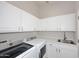 Spacious laundry room with white cabinets, countertop space, and modern appliances at 6323 E Nisbet Rd, Scottsdale, AZ 85254