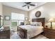 Charming bedroom with a wood frame bed, ceiling fan, and bright window at 6340 E Marioca Cir, Scottsdale, AZ 85266