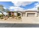 Charming single-story home with a three-car garage and desert landscaping in front at 6340 E Marioca Cir, Scottsdale, AZ 85266