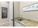 Bright laundry room with granite counters, utility sink, white cabinetry, and decorative metal art at 6340 E Marioca Cir, Scottsdale, AZ 85266