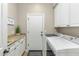 Well-equipped laundry room with washer, dryer, granite counters, and ample storage cabinets at 6340 E Marioca Cir, Scottsdale, AZ 85266
