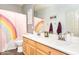 Bright bathroom featuring a double sink vanity, rainbow shower curtain, and modern finishes at 6920 W Tether Trl, Peoria, AZ 85383