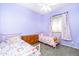 Charming bedroom with purple walls and bedding, ceiling fan, and window with rainbow curtains at 6920 W Tether Trl, Peoria, AZ 85383