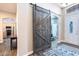 Foyer featuring a large sliding barn door, decorative light fixture, beautiful door with glass and shutters at 6920 W Tether Trl, Peoria, AZ 85383