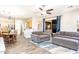 Open-concept living room featuring wood floors, a ceiling fan, and a sliding glass door to the outdoor space at 6920 W Tether Trl, Peoria, AZ 85383