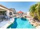 Beautiful backyard pool with stone waterfall, covered seating, and a serene outdoor living space at 6920 W Tether Trl, Peoria, AZ 85383