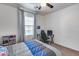 Bright bedroom with a ceiling fan, natural light, a desk setup, and a bed with blue and gray bedding at 7015 S Stadium Ct, Gilbert, AZ 85298
