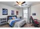 Comfortable bedroom featuring vibrant posters, a ceiling fan, a desk, and a bed with striped bedding at 7015 S Stadium Ct, Gilbert, AZ 85298