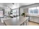 Kitchen island with sink and view of the living room featuring neutral color palette and natural light at 7015 S Stadium Ct, Gilbert, AZ 85298