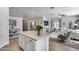 Bright kitchen featuring an island, white cabinets, and open concept to a cozy living space with fireplace at 7015 S Stadium Ct, Gilbert, AZ 85298