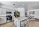 Bright kitchen with stainless appliances, kitchen island with bar stool seating, and open to dining area at 7015 S Stadium Ct, Gilbert, AZ 85298