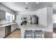Functional kitchen with stainless steel appliances, an island with barstool seating and white cabinets at 7015 S Stadium Ct, Gilbert, AZ 85298