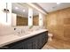 Elegant bathroom featuring dual sinks, modern fixtures, and beautiful travertine tile accents at 7151 E Rancho Vista Dr # 2006, Scottsdale, AZ 85251