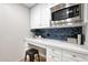 This additional counter space has a small desk, white cabinets, a stainless microwave, and designer backsplash at 7151 E Rancho Vista Dr # 2006, Scottsdale, AZ 85251