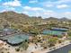 Aerial view of community tennis courts and parking, set against a backdrop of desert landscape and mountains at 7739 E Evening Glow Dr, Scottsdale, AZ 85266