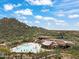 An aerial view showcases the community pool and clubhouse nestled amidst the desert landscape and mountains at 7739 E Evening Glow Dr, Scottsdale, AZ 85266