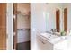 Modern bathroom vanity with white cabinets, square sink, large mirror, and an open closet with shelving at 7739 E Evening Glow Dr, Scottsdale, AZ 85266