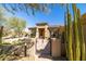 A single-story home features desert landscaping, an iron gate, and a terracotta-colored exterior, blending seamlessly with the scenery at 7739 E Evening Glow Dr, Scottsdale, AZ 85266