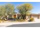 Desert landscaping complements this home with a side garage, complemented by mature trees and native cacti at 7739 E Evening Glow Dr, Scottsdale, AZ 85266