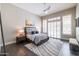 Bright, spacious bedroom with dark wood floors, complemented by large windows and a cozy rug at 7739 E Evening Glow Dr, Scottsdale, AZ 85266