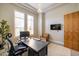 A home office featuring plantation shutters and a modern desk at 7739 E Evening Glow Dr, Scottsdale, AZ 85266