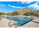 Community pool featuring a sundeck with lounge chairs and mountain views on a bright, sunny day at 7739 E Evening Glow Dr, Scottsdale, AZ 85266