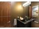 Stylish powder room featuring a unique bowl sink and modern fixtures, enhanced by warm, ambient lighting at 7739 E Evening Glow Dr, Scottsdale, AZ 85266