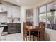 Cozy kitchen with white cabinets, stainless steel appliances, and a kitchen table near the window at 7942 E Nopal Ave, Mesa, AZ 85209