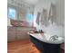 Elegant bathroom featuring a freestanding tub, wood floors, and unique wall decor at 81 W Lynwood St, Phoenix, AZ 85003