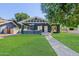 Charming single-story home with lush front lawn, Craftsman details, and inviting covered porch at 81 W Lynwood St, Phoenix, AZ 85003